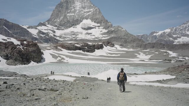 Adventurous hiker exploring the stunning alpine scenery of the snowy swiss alps near zermatt