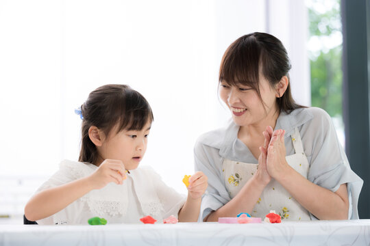 母親や先生と一緒に粘土遊びを楽しみながら創造力を育む親子・知育遊びの時間　発達支援や療育、子育てのイメージ