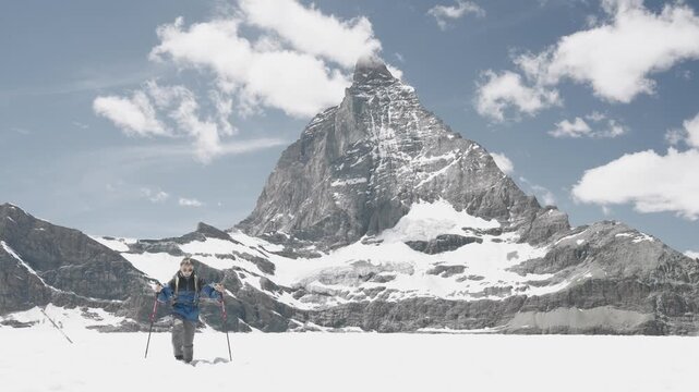 Young man trekking on a glacier in winter with the famous matterhorn peak in the background