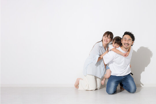 白背景で仲良し笑顔の家族・幸せなファミリーライフと健康的な暮らし　保険やnisaなど教育や成長　全身で座る半袖夏イメージに