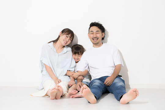 白背景で仲良し笑顔の家族・幸せなファミリーライフと健康的な暮らし　保険やnisaなど教育や成長　全身で座る半袖夏イメージに