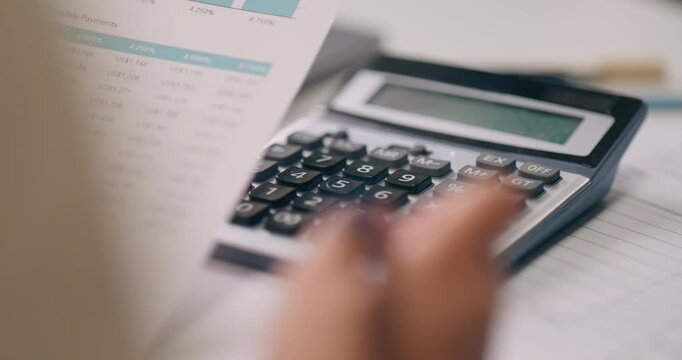 Close-up financial analyst hand using calculator to compute mortgage loan options and interest calculation on desk.
