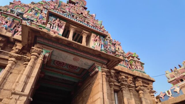 Low angle view looking up at a vibrant, intricately sculpted Hindu temple Gopuram in South India