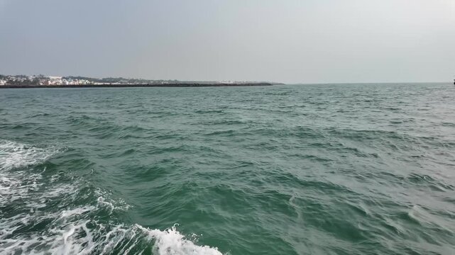 ea wake and white foam from a tourist ferry boat cruising the ocean in Kanyakumari.