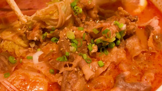 Close Up of Spicy Beef Hot Pot with Enoki Mushrooms