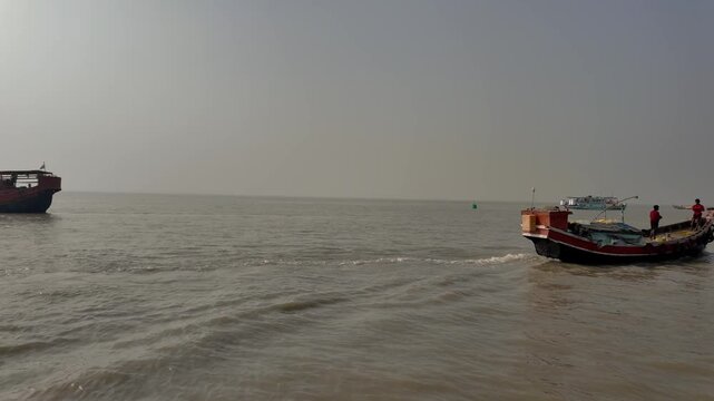 Traditional wooden ferry boats navigating the sea at Gangasagar, Sagar Island, West Bengal, India
