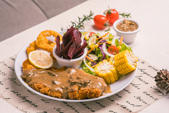 Imagine the crunch of premium, golden-brown, and juicy Chicken Katsu paired with top-notch, crispy onion rings. It doesn't stop there&mdash;fresh salad adds a burst of freshness, while sweet corn kernels ma