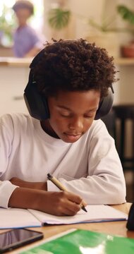 Writing, headphones and child with book for education, homework and practice mathematics in home. Study, notebook and kid with tech for lesson tips, development or productivity with audio assessment