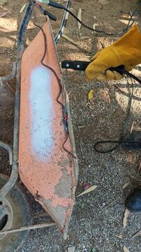 Welding steel wire rod to reinforce the chassis of an old construction wheelbarrow