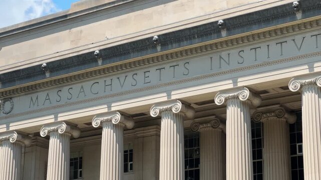 Close-up of MIT&rsquo;s Building 10 facade, centered on the carved &ldquo;Massachusetts Institute of Technology&rdquo; inscription above the Ionic columns. The columns and inscription are the classic front of the Macla