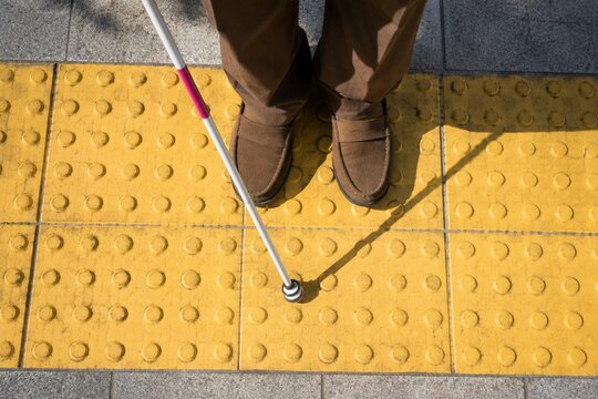 White cane on tactile paving for visually impaired pedestrian