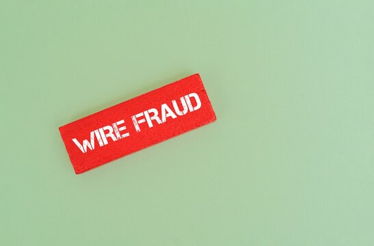 A coloured blocks with "WIRE FRAUD" text against coloured background. Financial crime, cyber security, and internet scam concept
