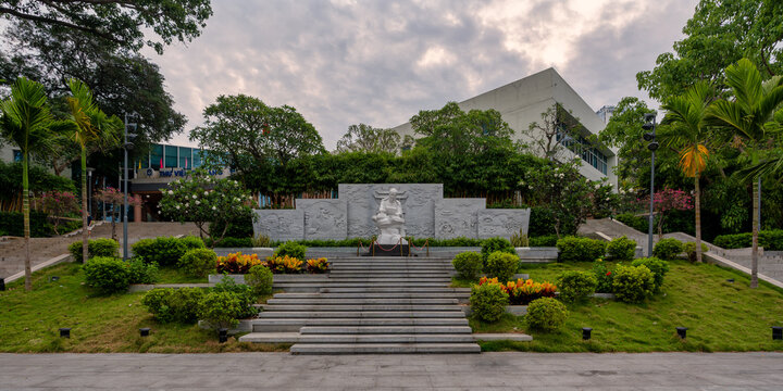 Da Nang, Vietnam - April 28, 2026: Statue of Ho Chi Minh in front of the General Science Library building featuring a stone relief wall and landscaped gardens