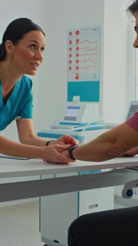Healthcare professional tracks patient data. Registered nurse records vital signs during consultation. Professional nurse employs smartwatch to document patient health metrics accurately