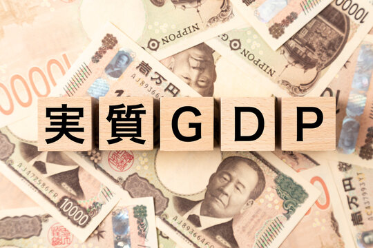 「実質GDP」と書かれたブロックとたくさんの一万円札