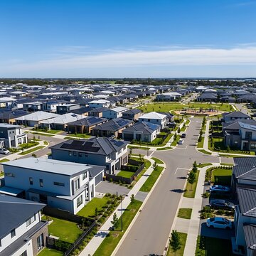 Modern Suburban Houses Arranged Along Curved Streets Under Clear Blue Sky
