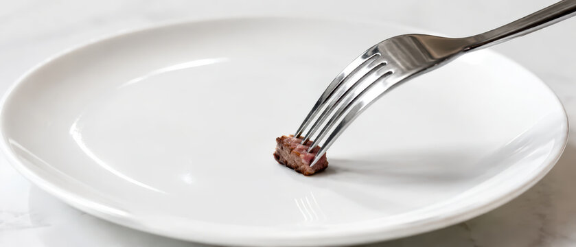 Small piece of steak on fork on empty white plate representing global economy inflation impact on food portion and consumption