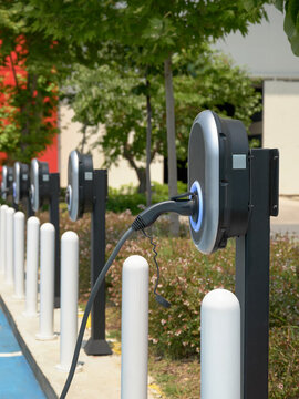 Close-up of an electric car charging station in the city against the backdrop of an office building.