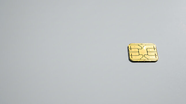 Golden Electronic Microchip Component for Smart Card and SIM Technology on Plain Gray Background