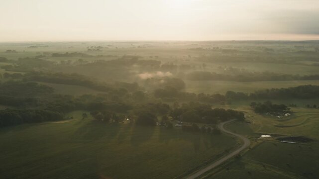 A foggy sunrise over rural Iowa land.