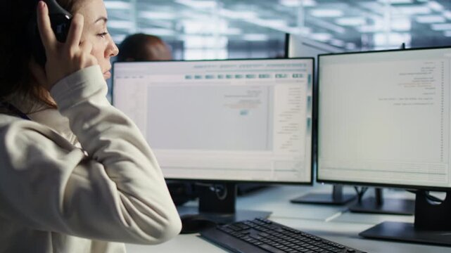 Data center technician wearing headphones inspecting rackmounts, close up from a secondary camera angle while combining power management, hardware monitoring and server room operations.