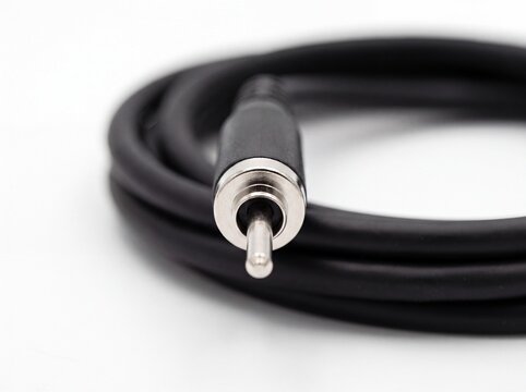 Close up coiled black fiber optic cable with connector on white background