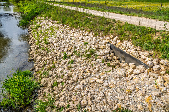 Natural riverbank erosion control with rocks and drainage pipe