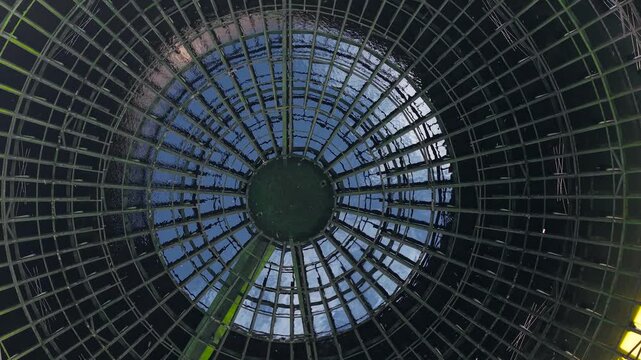 Inside nuclear reactor cooling tower with circular steel grid and reflective water surface. Energy infrastructure concept highlighting global energy crisis and power generation technology. Symmetrical