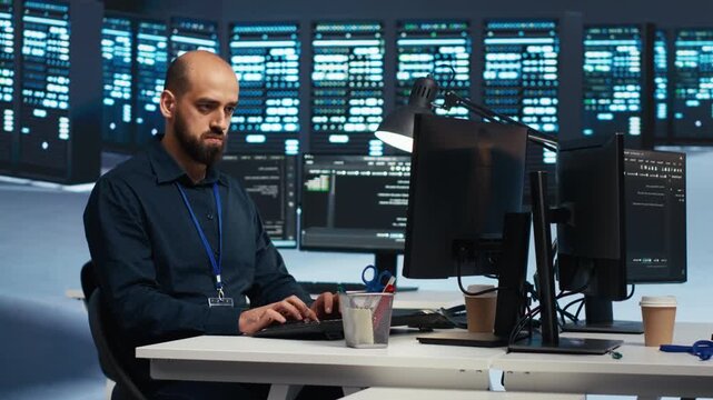 IT programmer codes in a server farm while safeguarding supercomputers and data from unauthorized access, threats and virus attacks during a secure infrastructure workflow.
