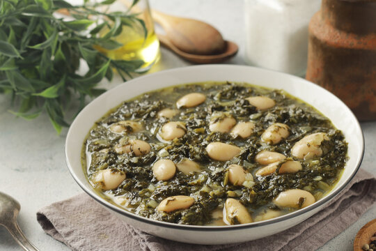 A bowl with traditional Tuscan kale salad and white beans soup Cavolo nero e fagioli	