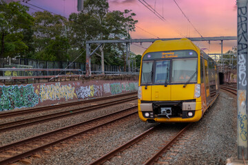 Fototapeta premium 7 July 2026 Passenger Train going through Lewisham Train Station at Sunset a suburban Sydney train Station in Sydney NSW Australia