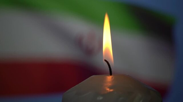 Lit candle flame glows brightly. Wax surface shows subtle details. Blurred Italian flag colors form background. Symbolizes hope or remembrance. Ideal for events like commemorations or ceremonies