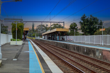 Naklejka premium 7 July 2026 Passenger Train going through Lewisham Train Station at Sunset a suburban Sydney train Station in Sydney NSW Australia