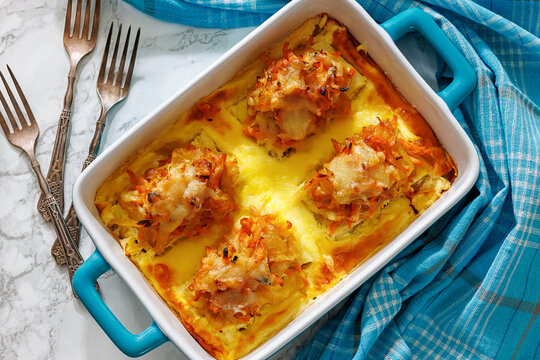 Cheesy Veggie Baked White Fish in blue baking dish