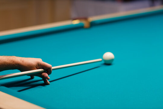 Billiard player hand at billiard table or snooker billiards pool sport game