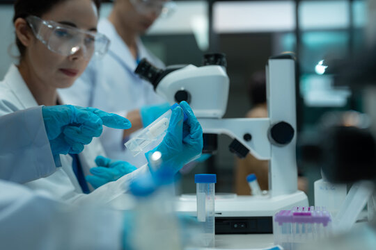 Environmental scientist testing water quality sample for microplastics and chemical contaminants in laboratory.