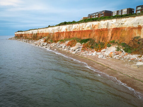 Dramatic view of the famous Jurassic cliffs at Hunstanton, Norfolk, UK in mid summer. Heavy coastal erosion is taking place as can be seen from the fallen rocks and boulders.