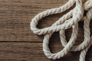 Fototapeta premium Twisted Natural Rope on Rustic Wooden Background for Crafts