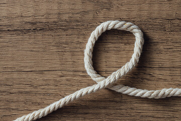 Obraz premium Close-Up View of Twisted Natural Fiber Rope on Wooden Background