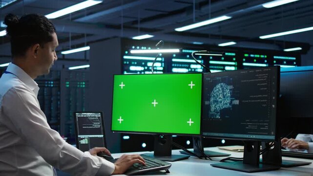 In a server room, engineer uses a replaceable screen device with a chroma key computer monitor, supporting network security, data protection and screen replacement during practical IT operations