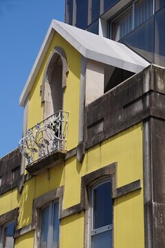 Yellow building facade with ornate balcony railing under blue sky. Portugal - Norte