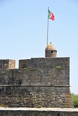 Portugal flag flying over ancient castle wall turret. Portugal - Norte © insideportugal