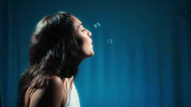 Young smiling woman smiling and blowing soap bubbles in a dream room