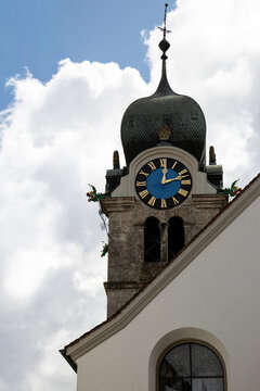 Historic church tower with ornate dome and clock face in Eglisau, Switzerland