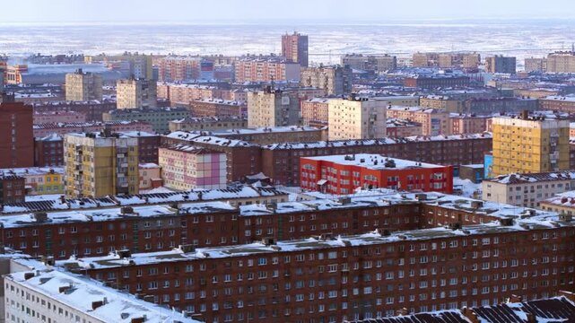 Golden hour light reflecting on colorful soviet era apartment blocks in a snowy Russian city