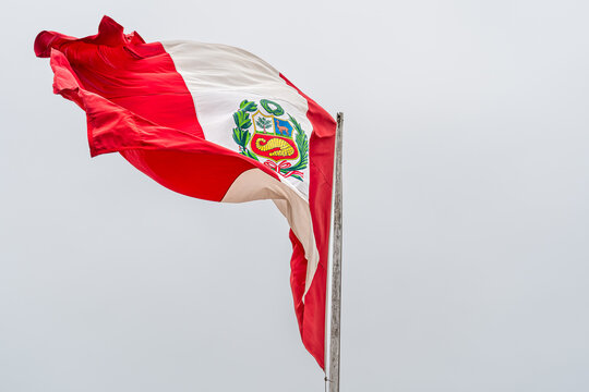 Peruvian Flag with National Emblem Waving in the Wind