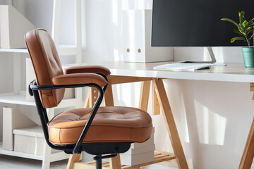 Fototapeta premium Modern home office interior with a brown leather ergonomic chair and a computer monitor on a white desk