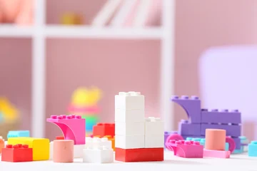 Fotobehang Lego Colorful plastic building blocks on white table in childrens room  © Pixel-Shot