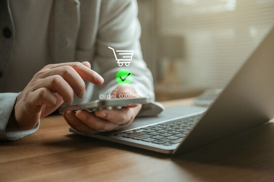 Online shopping order confirmation displayed on smartphone, laptop in modern workspace, secure mobile payment, ecommerce checkout, digital transaction, customer purchase success, fintech technology.