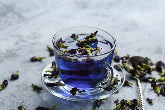Glass cup of butterfly pea flower tea on grunge background